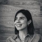 A woman in a denim shirt smiles for the camera