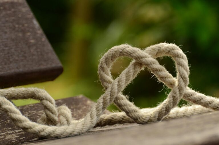 Brown Rope Tangled and Formed Into Heart Shape on Brown Wooden Rail
